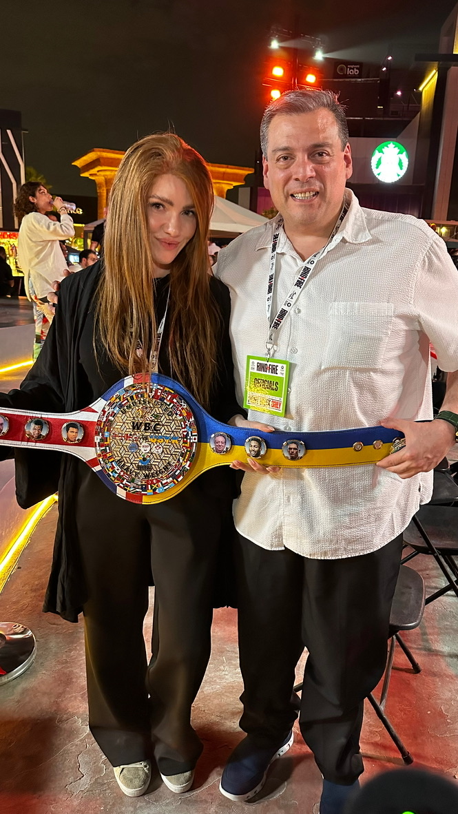 Kristen and a colleague holding a WBC championship belt at the fight week event, Riyadh