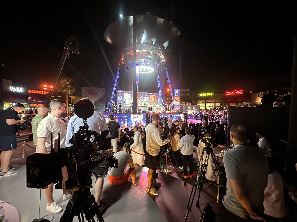 Fight week press event stage with cameras and crowd at night, Riyadh